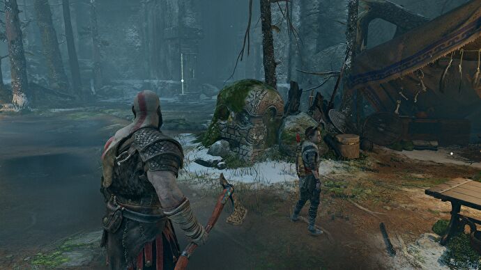 Kratos se tient devant une pierre en forme de crâne dans God of War.  Affiche une résolution native de 1440p.
