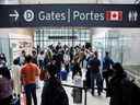 Les voyageurs se pressent dans la file d'attente de sécurité dans la salle des départs au début du long week-end de la fête de Victoria à l'aéroport international Pearson de Toronto à Mississauga, en Ontario, le 20 mai 2022.