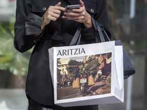 Une femme avec un sac à provisions Aritzia à Toronto.