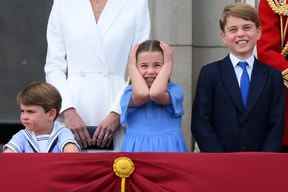 La princesse Charlotte se couvre les oreilles alors qu'elle se tient avec les frères le prince Louis et le prince George pour assister à un défilé aérien spécial depuis le balcon du palais de Buckingham après le défilé de l'anniversaire de la reine, le défilé de la couleur le 2 juin 2022. (Photo de DANIEL LEAL/AFP via Getty Images )