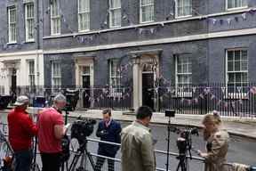 Des membres des médias travaillent à l'extérieur du 10 Downing Street, la résidence officielle du Premier ministre britannique, dans le centre de Londres, le 6 juin 2022. (Photo de HOLLIE ADAMS/AFP via Getty Images)