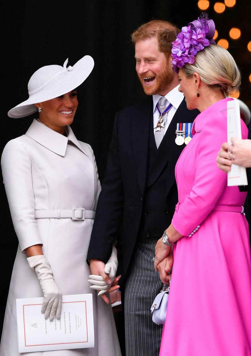 Le prince britannique Harry (C) et son épouse Meghan, le duc et la duchesse de Sussex, s'adressent à Zara Tindall (R) à la fin du service national d'action de grâces pour le règne de la reine à la cathédrale Saint-Paul de Londres le 3 juin 2022 comme dans le cadre des célébrations du jubilé de platine de la reine Elizabeth II.  - La reine Elizabeth II a lancé le premier des quatre jours de célébrations marquant ses 70 ans record sur le trône, devant des foules de dizaines de milliers de personnes.  Mais l'apparition de la souveraine de 96 ans au jubilé de platine – une étape jamais atteinte auparavant par un monarque britannique – a fait des ravages, la forçant à se retirer d'un service religieux prévu.  (Photo de TOBY MELVILLE / POOL / AFP) (Photo de TOBY MELVILLE/POOL/AFP via Getty Images)