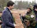 Le Premier ministre canadien Justin Trudeau, à gauche, s'entretient avec un soldat canadien lors de sa visite à la base militaire d'Adazi à Kadaga, en Lettonie, le mardi mars.  8, 2022.