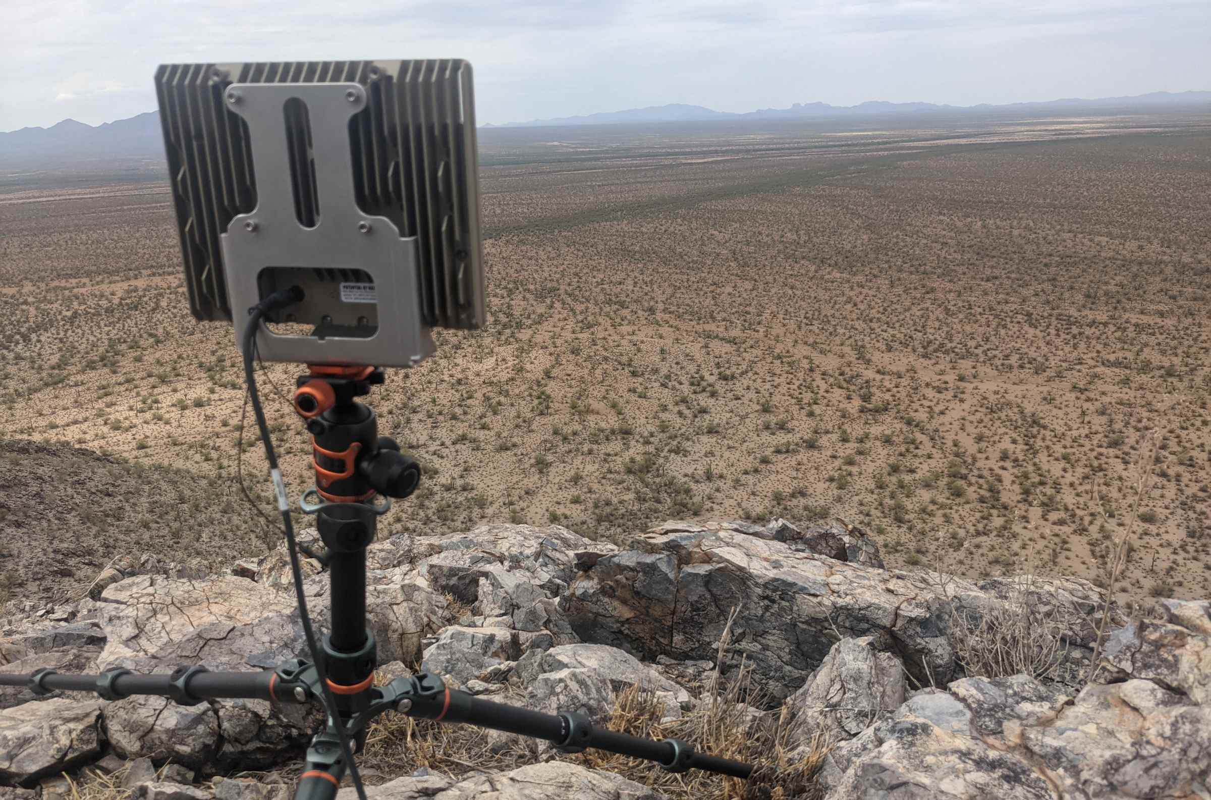Un radar Echodyne sur un petit trépied surveillant une zone désertique.