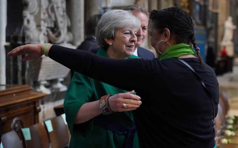 Theresa May est embrassée par la bénévole communautaire Claire Walker au service commémoratif – Jonathan Brady / PA