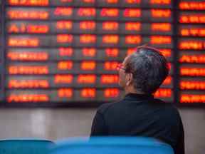 Un investisseur regarde des écrans montrant les mouvements boursiers en Chine.
