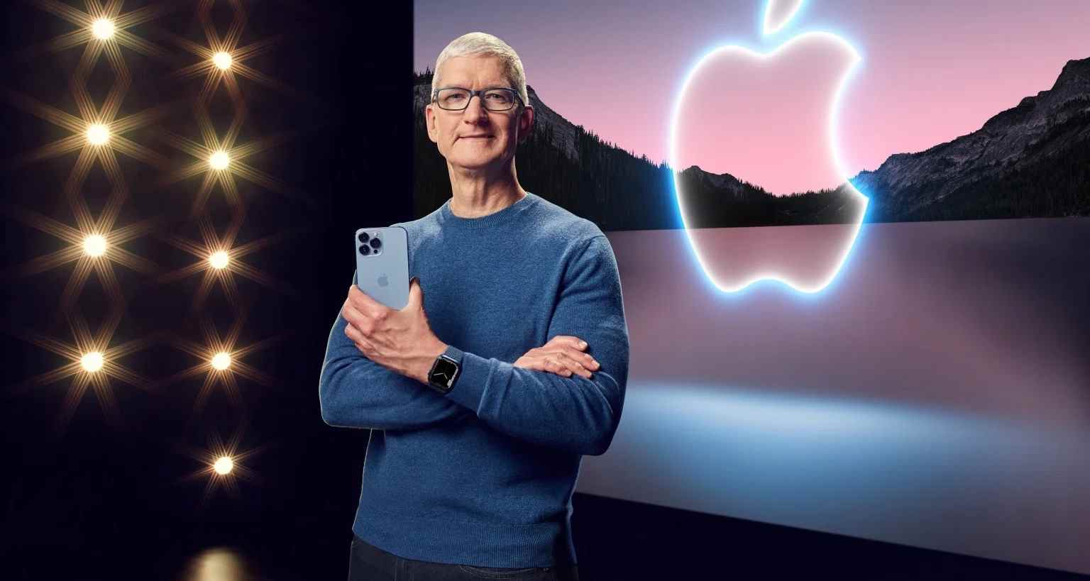 Tim Cook avec un iPhone devant le logo Apple