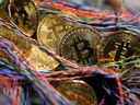 Des bitcoins se trouvent parmi des câbles en cuivre torsadés dans un bureau à Londres, au Royaume-Uni, le 5 septembre 2017. 