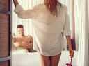 Jolie femme séduisante à la porte de la chambre pendant que son petit ami est au lit