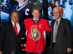 Dossiers : Daniel Alfredsson, (C), avec Eugene Melnyk (L) et Bryan Murray, (R) en décembre 2014 lors de la conférence de presse où l'ancien capitaine des Sénateurs d'Ottawa a signé un contrat d'une journée lui permettant de prendre sa retraite en tant que sénateur d'Ottawa .