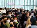 Les voyageurs se pressent dans la file d'attente de sécurité dans la salle des départs au début du long week-end de la fête de Victoria à l'aéroport international Pearson de Toronto à Mississauga, Ontario, Canada, le 20 mai 2022.  
