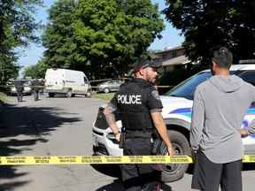 Un homme parle à la police avant d'être laissé entrer dans la maison voisine de celle de la rue Anoka où la police d'Ottawa et l'UES enquêtaient sur trois décès mardi.  Julie Oliver/Postmédia
