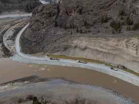 Des camions transportent des charges de roches sur un tronçon de la route 8 le long de la rivière Nicola, qui a dû être reconstruit après avoir été emporté lors des inondations de novembre qui ont touché la bande indienne de Shackan, au nord-ouest de Merritt, en Colombie-Britannique, le jeudi 24 mars 2022.