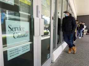 Des gens font la queue devant un bureau de Service Canada à Vancouver en avril.  Beaucoup ont attendu plus de quatre heures avant même d'entrer dans le bureau.