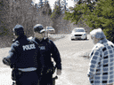 Des agents de la GRC parlent avec un homme à Portapique, en Nouvelle-Écosse, après la fin de la recherche d'un suspect de tir de masse le 19 avril 2020.