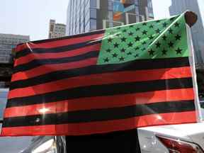 Un homme tient un drapeau afro-américain lors d'une manifestation à Chicago le 19 juin 2020.