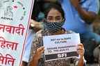 Des militants de la Student Federation of India (SFI) et de l'All India Democratic Women's Association (AIDWA) tiennent des pancartes lors d'une manifestation contre le viol et le meurtre présumés d'une fillette de neuf ans, à New Delhi le 4 août 2021.