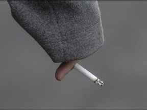 Un piéton traverse la rue Bloor en tenant une cigarette allumée à Toronto, en décembre 2019.