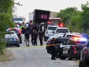 Des agents des forces de l'ordre travaillent sur les lieux où des personnes ont été retrouvées mortes à l'intérieur d'un camion remorque à San Antonio, Texas, le 27 juin 2022.
