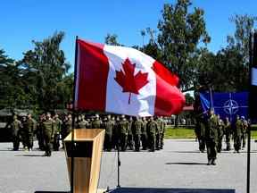 Des soldats assistent à une cérémonie de célébration du 5e anniversaire du groupement tactique de la présence avancée renforcée de l'OTAN dirigé par le Canada à Adazi, en Lettonie, le 15 juin 2022.