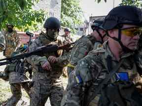 Des membres de l'unité de volontaires étrangers qui combattent dans l'armée ukrainienne marchent, alors que l'attaque de la Russie contre l'Ukraine se poursuit, à Sievierodonetsk, région de Luhansk Ukraine le 2 juin 2022. Photo prise le 2 juin 2022. REUTERS/Serhii Nuzhnenko