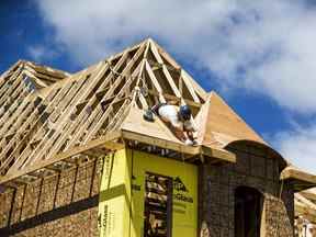Un travailleur de la construction travaille sur une nouvelle maison en construction dans une banlieue située au nord de Toronto à Vaughan, en Ontario.