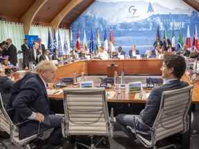 Le Premier ministre Justin Trudeau et le Premier ministre britannique Boris Johnson discutent avant une réunion avec des pays partenaires et des organisations internationales lors du Sommet du G7 à Schloss Elmau le lundi 27 juin 2022.