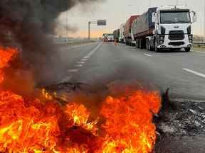 Des camions bloquent une autoroute près d'une barricade en feu à San Nicolas, en Argentine, alors que les camionneurs protestent contre les pénuries et la hausse des prix du carburant diesel, tout comme la récolte de céréales cruciale du pays nécessite des transports dans un contexte d'inflation galopante.