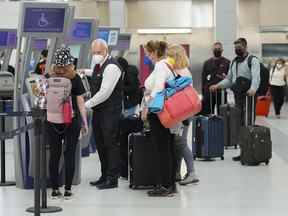 Les gens font la queue pour s'enregistrer à l'aéroport international Pearson de Toronto en mai 2022.