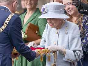 La reine Elizabeth inspecte les clés présentées par Lord Provost Robert Aldridge, à gauche, lors de la cérémonie des clés sur le parvis du palais de Holyroodhouse à Édimbourg le lundi 27 juin 2022.
