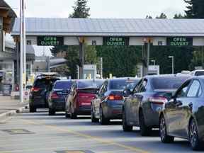 Une file de véhicules attend pour entrer au Canada au poste frontalier de Peace Arch à Blaine, Washington, le 9 août 2021.