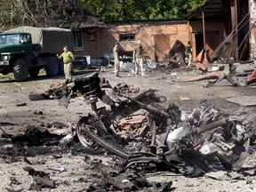 Des soldats enquêtent sur les dommages et récupèrent des objets après qu'un projectile et un incendie ont détruit un entrepôt la veille au soir le 21 juin 2022 à Druzhkivka, en Ukraine.