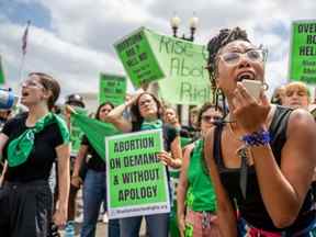 La manifestante du droit à l'avortement Elizabeth White mène un chant en réponse à la décision Dobbs v Jackson Women's Health Organization devant la Cour suprême des États-Unis le 24 juin 2022 à Washington, DC.