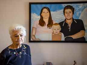 Donna Casasanta pose devant un tableau montrant son défunt fils, Harold Dean Clouse, avec la femme de Clouse, Tina Gail Linn, et leur fille, Hollie Marie Clouse, à Casasanta's Edgewater, en Floride, à domicile le vendredi 14 janvier 2022.