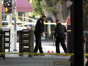 Des policiers de Sacramento examinent des marqueurs de preuves près de la scène d'une fusillade mortelle à l'extérieur d'une boîte de nuit du centre-ville de Sacramento, en Californie, tôt le matin le lundi 4 juillet 2022.