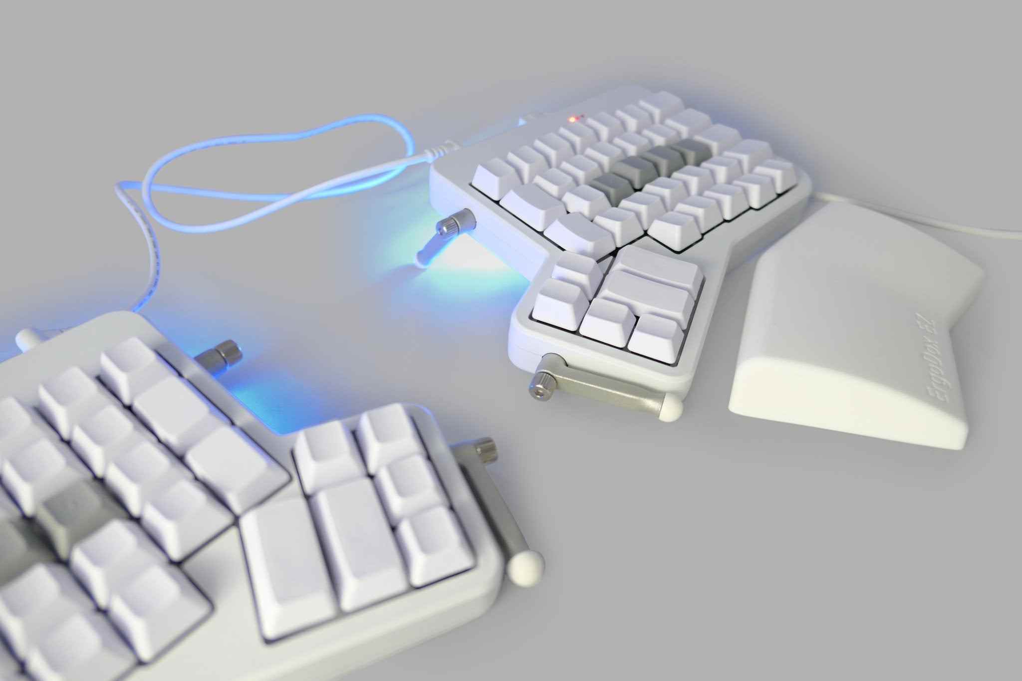 Un ErgoDox EZ, un clavier blanc divisé avec des touches vierges.