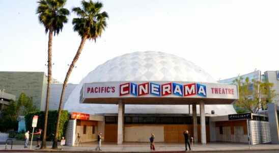 Bystanders gather outside the Cinerama Dome movie theater, Monday, April 12, 2021, in Los Angeles. Pacific Theaters, which operates some 300 screens in California, including the beloved ArcLight theaters and the historic Cinerama Dome in Hollywood, said Monday that it will not be reopening. Fans, including numerous actors, took to social media to share memories of the theater chain and lobby for it to be saved. (AP Photo/Chris Pizzello)