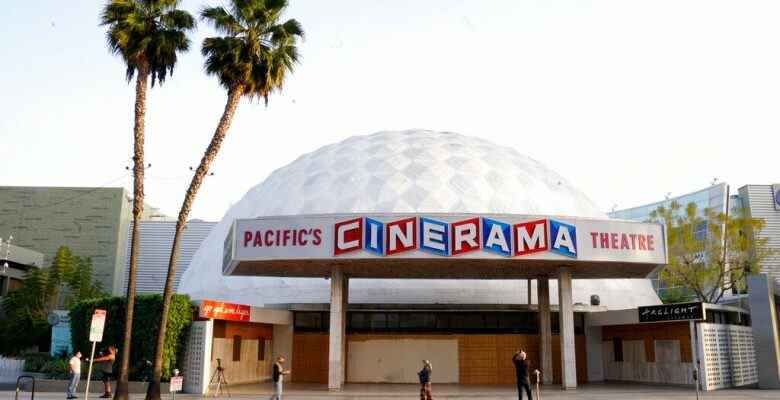 Bystanders gather outside the Cinerama Dome movie theater, Monday, April 12, 2021, in Los Angeles. Pacific Theaters, which operates some 300 screens in California, including the beloved ArcLight theaters and the historic Cinerama Dome in Hollywood, said Monday that it will not be reopening. Fans, including numerous actors, took to social media to share memories of the theater chain and lobby for it to be saved. (AP Photo/Chris Pizzello)