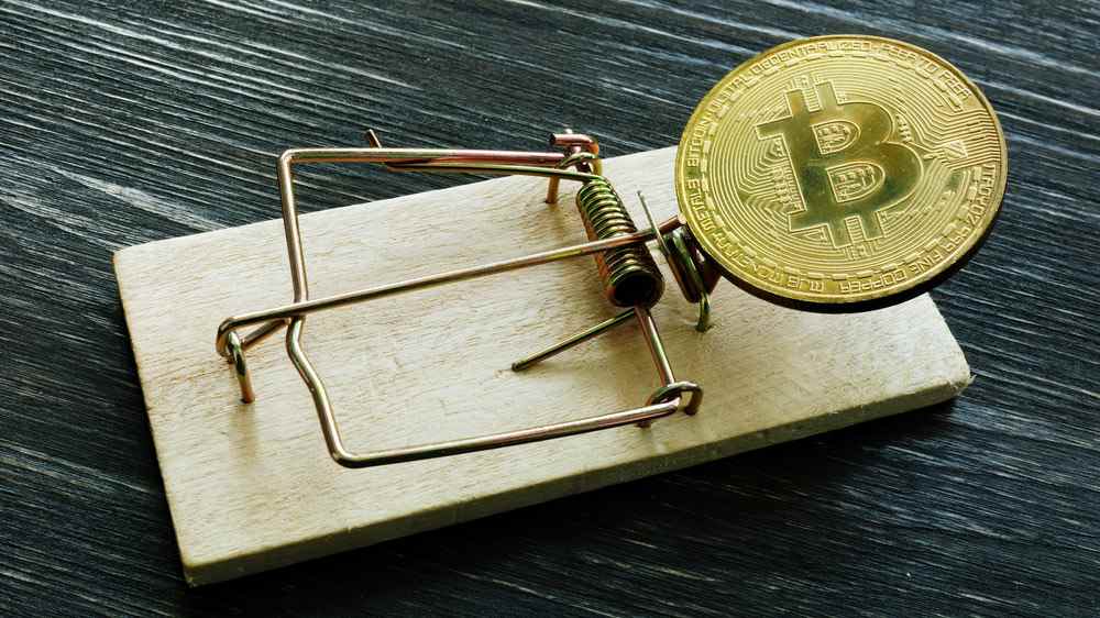 Un Bitcoin physique placé dans une souricière comme leurre.