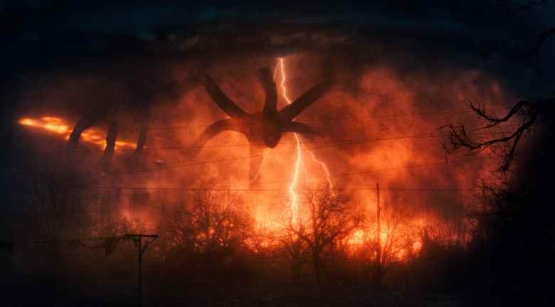 Un monstre ténébreux à plusieurs pattes plane au-dessus d'un paysage décimé et brûlé;  encore de "Choses étranges 2."
