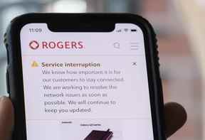 Une personne regarde son cellulaire affichant une alerte d'interruption de service de Rogers le vendredi 8 juillet 2022.
