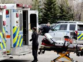 Un ambulancier travaille dans leur ambulance garée devant les entrées d'urgence de l'hôpital de l'Université de l'Alberta et de l'hôpital pour enfants Stollery, à Edmonton le mercredi 11 mai 2022.