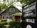L'enseigne d'un agent immobilier se trouve à l'extérieur d'une maison à vendre à Toronto.