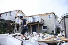 Un résident examine les dégâts laissés après qu'une tornade se soit abattue dans son quartier, à Barrie, en Ontario, le jeudi 15 juillet 2021. LA PRESSE CANADIENNE/Christopher Katsarov
