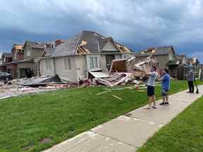 Des personnes inspectent des maisons endommagées à la suite d'une éventuelle tornade à Barrie le 15 juillet 2021. BRANDON VIEIRA/REUTERS
