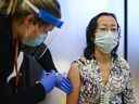 L'infirmière autorisée Clair Judd, à gauche, vaccine l'infirmière des SLD Yinghua Fang avec le vaccin à ARNm Pfizer-BioNTech COVID-19 pendant la pandémie de COVID-19 à Toronto le mardi 15 décembre 2020. Les éclosions de COVID-19 ont plus que doublé en Ontario à long terme foyers de soins au cours de la première semaine de juillet, selon Santé publique Ontario, alors que le secteur constate l'impact d'une septième vague de virus. LA PRESSE CANADIENNE/Nathan Denette