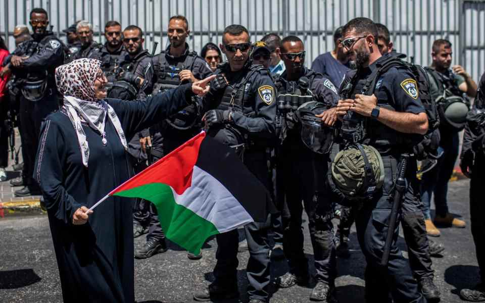 Une Palestinienne fait signe à un policier israélien lors d'une manifestation à Jérusalem-Est lors de la visite du président américain Joe Biden - Avalon