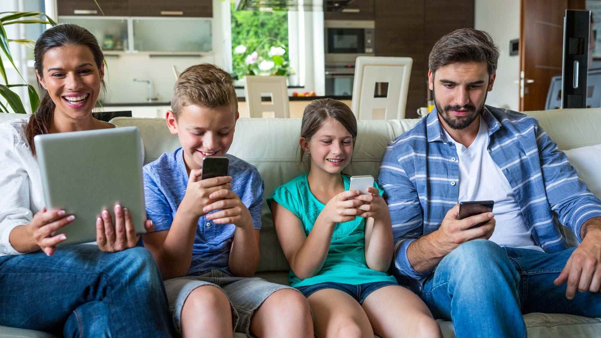 Une famille heureuse utilisant des appareils connectés à Internet
