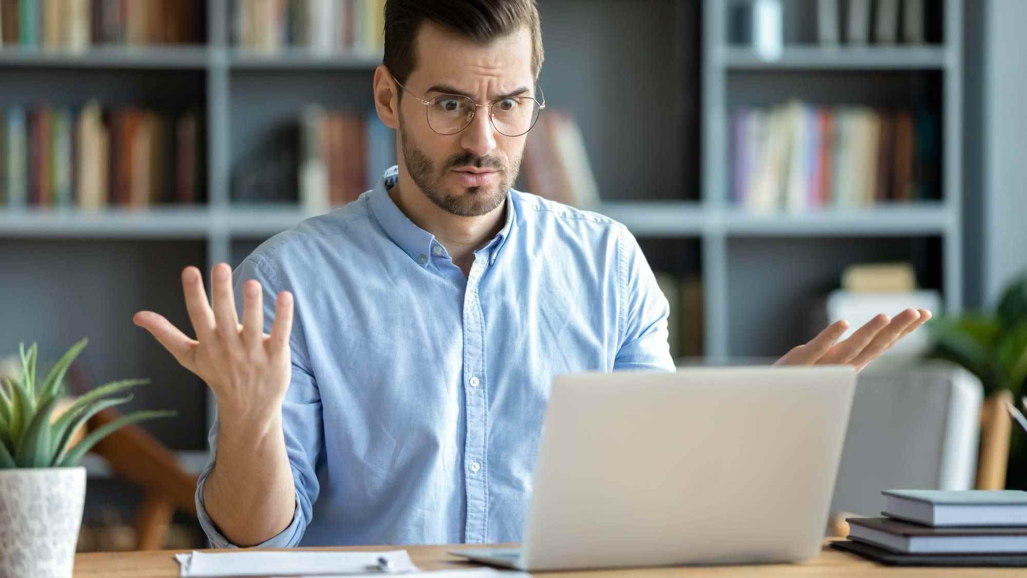 Un homme regardant son ordinateur avec incrédulité en raison de problèmes Internet