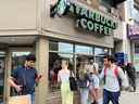 Les gens se pressent autour d'un café Starbucks pour utiliser son wifi gratuit sur le réseau Bell, lors d'une panne majeure des réseaux mobiles et Internet de Rogers Communications.